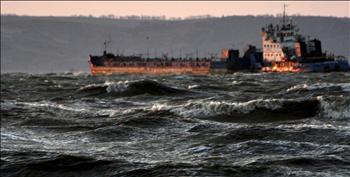 سفينة تبحر في مياه ملوثة، بعد الكارثة البيئية التي تسبّب بها انشطار ناقلة نفط روسية جراء عاصفة في مرفأ كيرتش في أوكرانيا على البحر الأسود أمس 